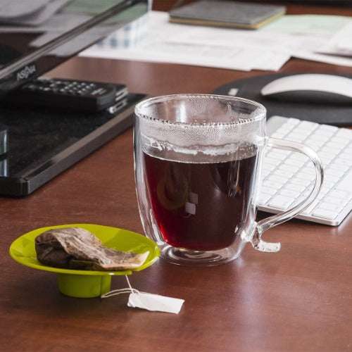 Double Wall Glass Mug with tea on desk next to tea bag on tea buddy