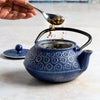 Floral 34 oz. Cast Iron Teapot putting in tea